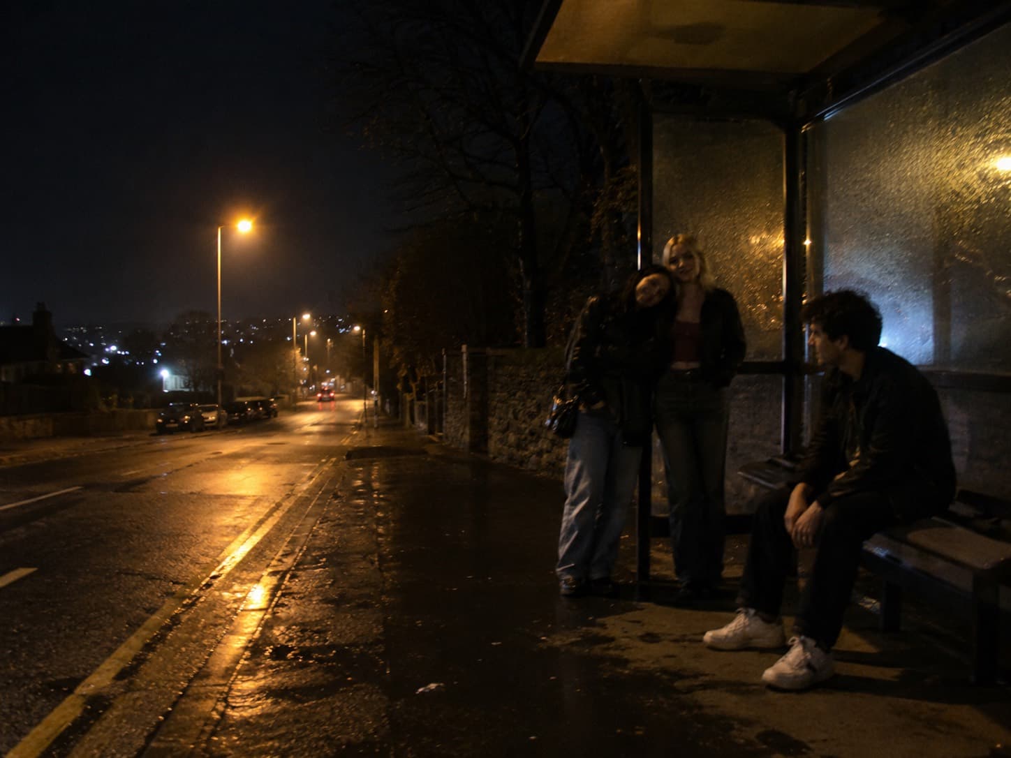 Friends waiting together for the night bus